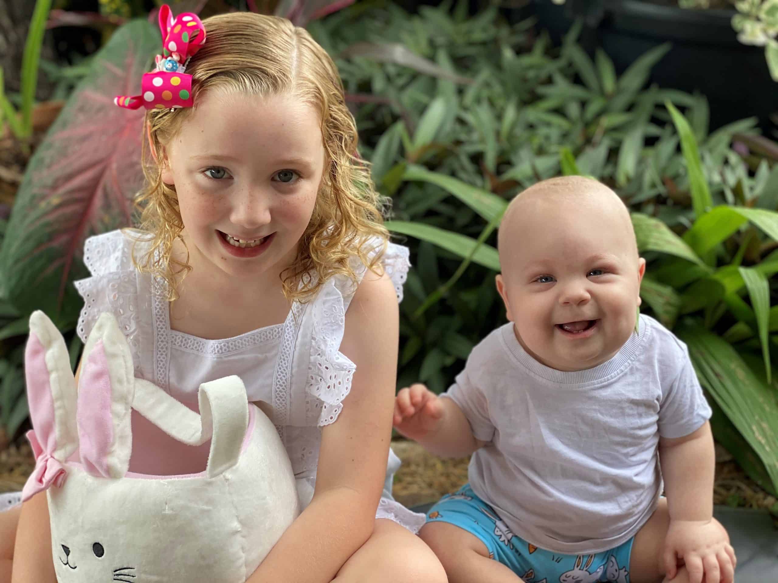 Baby with metopic synostosis and cystic fibrosis sitting with his older sister