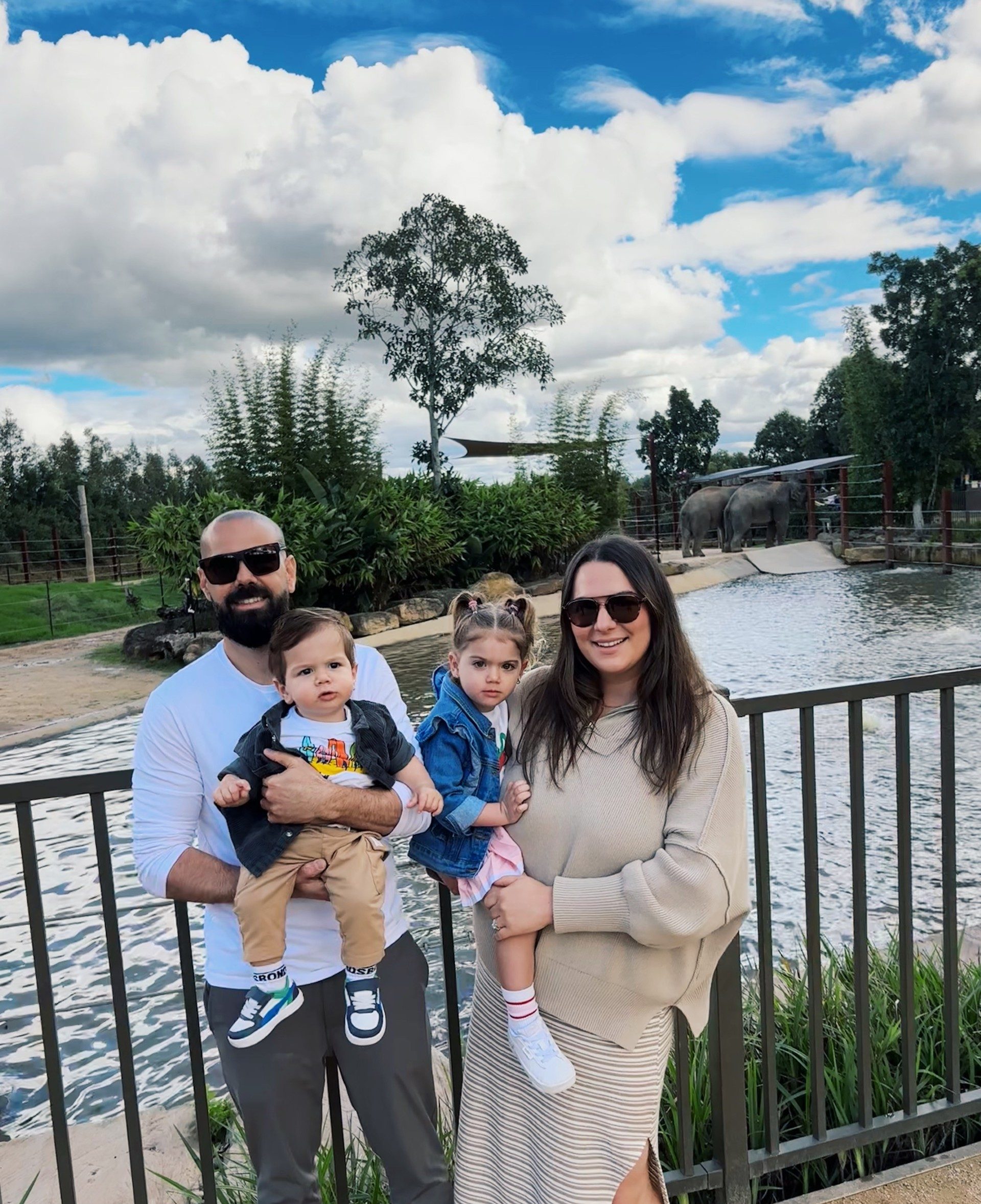 Family enjoying outdoor day at a zoo or park with water feature in Australia.
