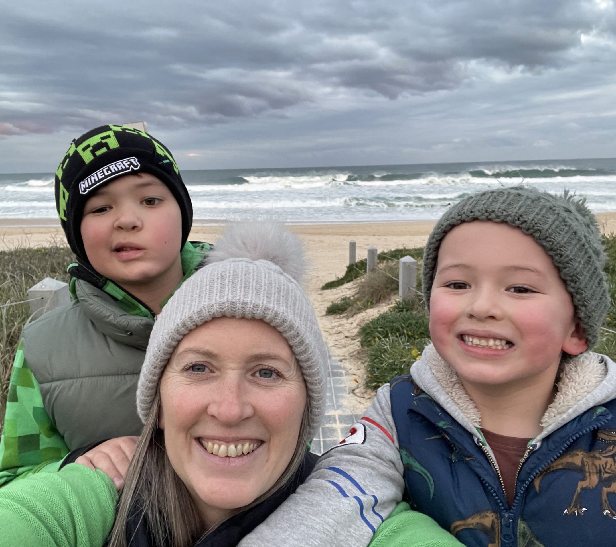 Boy who underwent surgery for a brain tumour and is undergoing facial reanimation therapy, with sibling and mother outdoors.