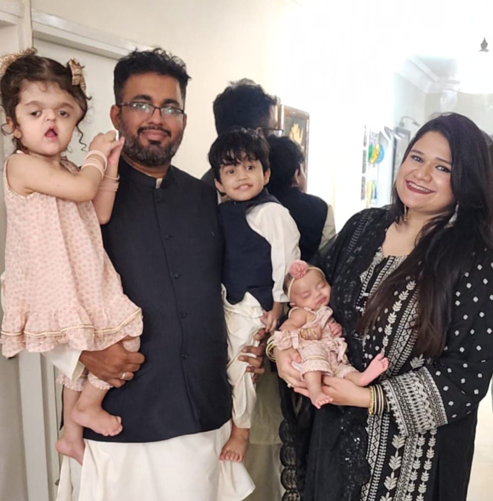 2 and a half year old Pakistani girl with Apert syndrome and her parents and siblings