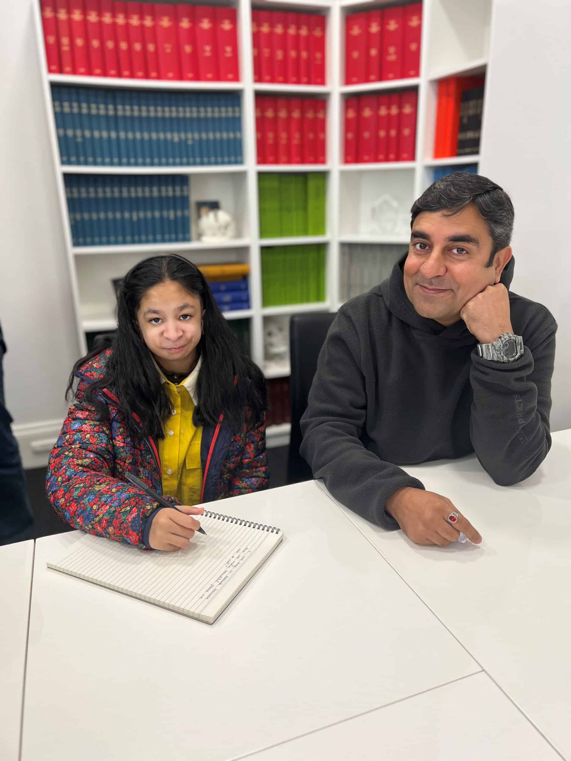 Girl with Nager Syndrome and her father sitting in the Craniofacial Australia offices.