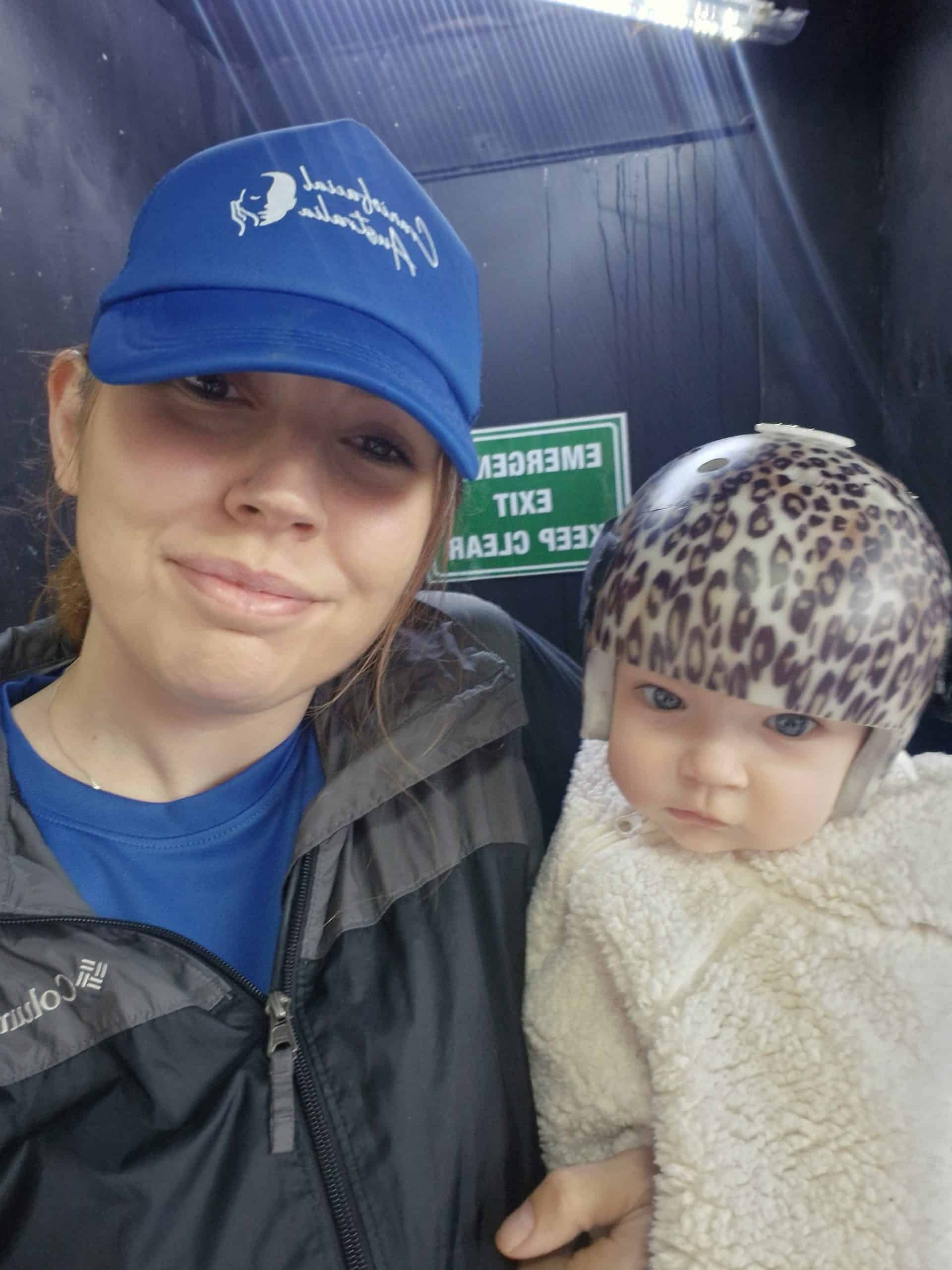Woman and child with leopard print hat at Craniofacial Australia event.